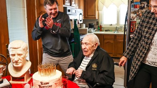 Georgia coach Kirby Smart (L) applauds for Hall of Famer Charley Trippi after Trippi blew out all the candles on his cake on the occasion of his 100th birthday at his home in Athens on Tuesday. Trippi's daughter, Barbara Fleeman, looks on.  (Photo by Tony Walsh/UGA Athletics)