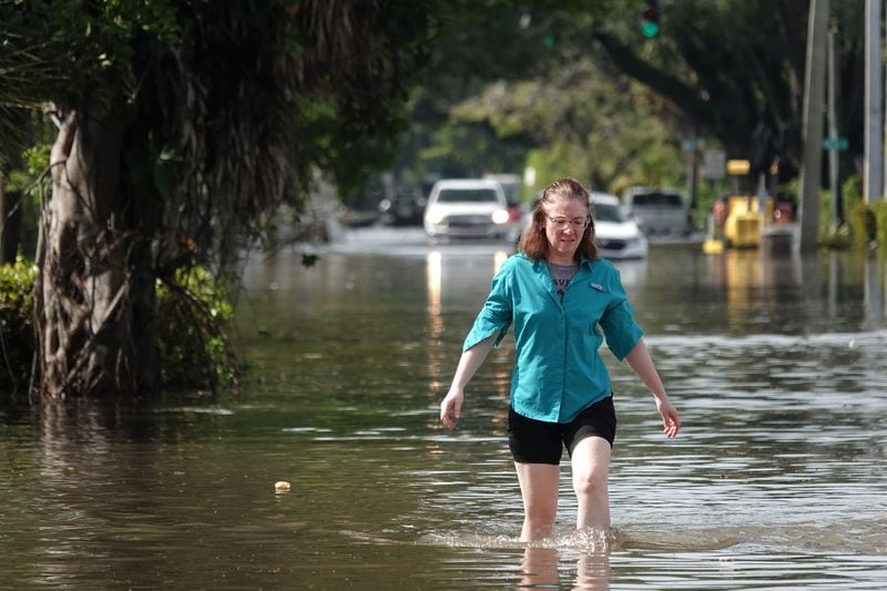 A woman wades through high flood waters in a Fort Lauderdale, Florida, neighborhood on Thursday, April 13, 2023. (Joe Cavaretta/South Florida Sun Sentinel/TNS)