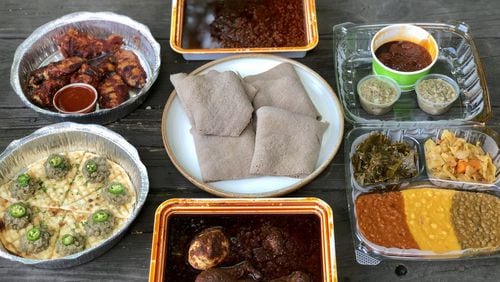 This takeout feast from Feedel Bistro features (clockwise from upper left): awaze wings; minchet abish key wet; vegan sampler; doro wet; azifah on pita; and injera (center). CONTRIBUTED BY WENDELL BROCK