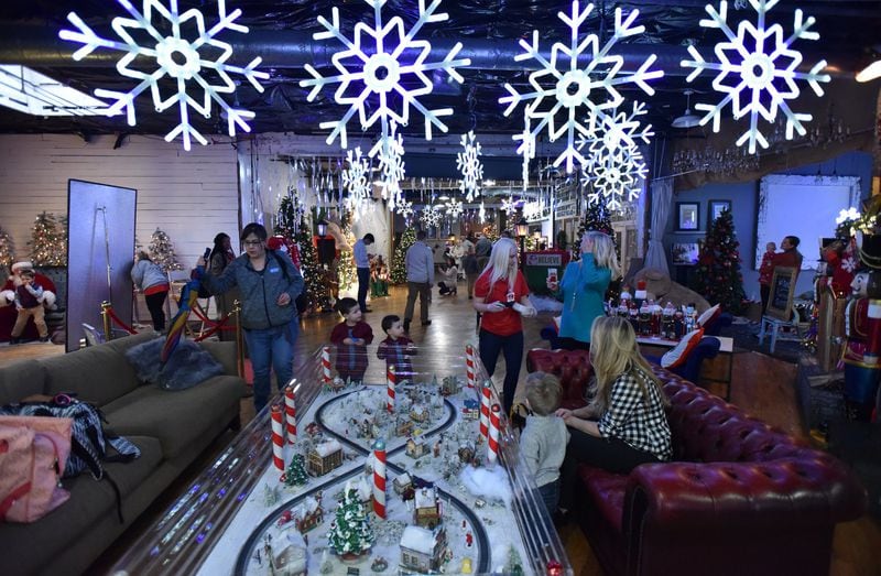 Photographer Jeff Roffman turns his studio into a winter wonderland, with fake snow, cookie decorating, and drinks for the grown-ups. This keeps the adults happy, keeps the children amused and gives them something to do while they wait to be photographed. HYOSUB SHIN / HSHIN@AJC.COM