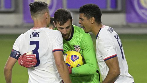 United States goalkeeper Matt Turner (center) is congratulated by defenders Aaron Long (3) and Miles Robinson (12) after stopping a penalty kick by Trinidad and Tobago defender Alvin Jones during the second half of an international friendly soccer match, Sunday, Jan. 31, 2021, in Orlando, Fla. (Phelan M. Ebenhack/AP)