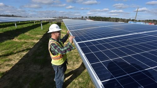 A worker with Solar Panel Solutions inspects solar panels in Bronwood, Ga. Solar energy accounts for only a small portion of Georgia’s electric power. But the sun is generating a growing segment of the state’s energy picture. HYOSUB SHIN / HSHIN@AJC.COM