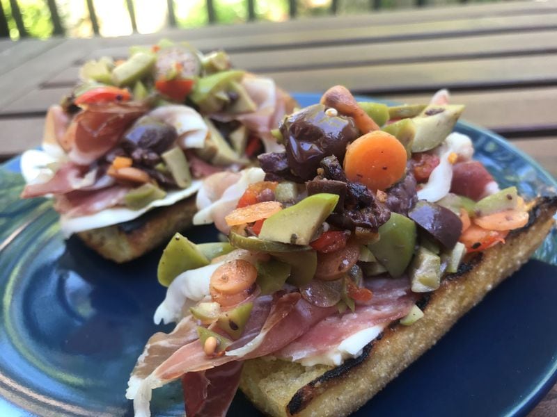 The ham and cheese bruschetta from Italian-American restaurant BoccaLupo is piled with smoked prosciutto and a loose tapenade that offers brininess, color and texture. It makes a great starter for two. LIGAYA FIGUERAS / LIGAYA.FIGUERAS@AJC.COM