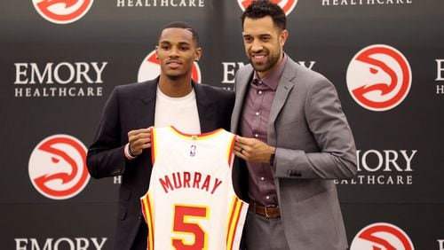 Hawks guard Dejounte Murray holds his No. 5 jersey with general manager Landry Fields during Murray’s introductory news conference July 1 at the Emory Sports Medicine Complex in Atlanta. (Jason Getz / Jason.Getz@ajc.com)