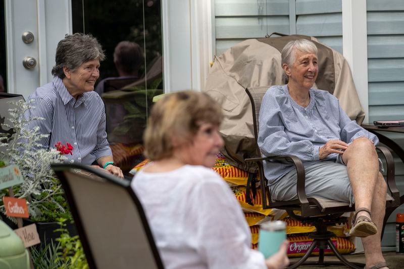 Carolyn Chandler (right) and Mary Bell (left) speak with other women at a weekly outdoor meetup in Avondale Estates. Each Tuesday, weather permitting, Chandler and Bell open their backyard to whoever is interested in hanging out, at a social distance, to catch up and chat. (ALYSSA POINTER / ALYSSA.POINTER@AJC.COM)