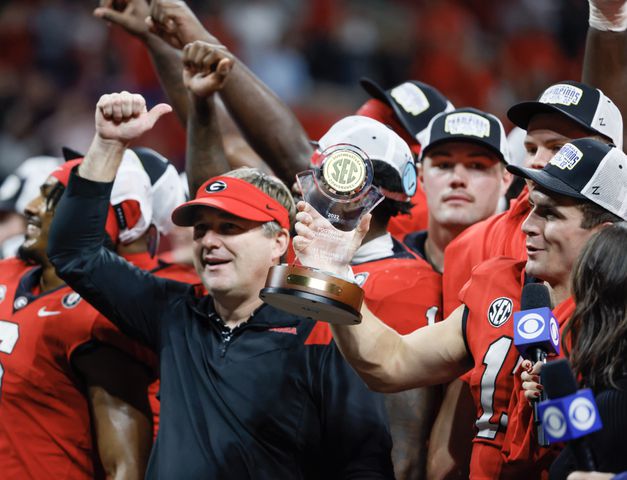 Georgia Bulldogs head coach Kirby Smart and  Stetson Bennett celebrate on the awards stand after UGA defeated LSU 50 - 30 in the SEC Championship between the Georgia Bulldogs and the LSU Tigers In Atlanta on Saturday, Dec. 3, 2022. (Bob Andres / Bob Andres for the Atlanta Constitution)