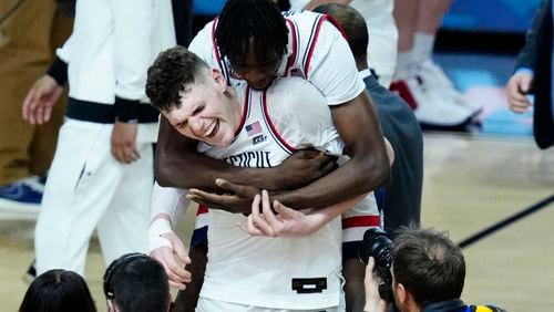 UConn center Youssouf Singare, rear, hugs orward Alex Karaban after the NCAA college basketball game against Alabama at the Final Four, Saturday, April 6, 2024, in Glendale, Ariz. (AP Photo/Ross D. Franklin)
