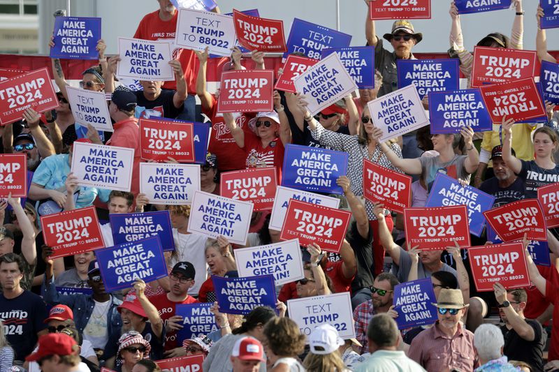 Supporters wave signs before former President Donald Trump speaks at a rally in Wilmington, N.C., Saturday, April 20, 2024. Trump never spoke, as the event was canceled because of threatening weather. (AP Photo/Chris Seward)
