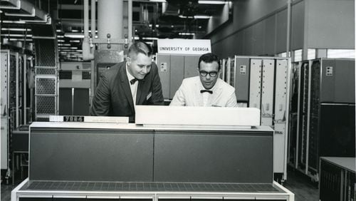 James L. Carmon (left) stands surrounded by an IBM 7094, which, in 1964, was the state-of-the-art supercomputer. Carmon helped acquire a 7094 for the University of Georgia, which eventually put UGA in the service of the Apollo program. CONTRIBUTED BY UNIVERSITY OF GEORGIA