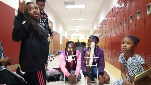 Makenzie Tucker, Zola Stewart, Miracle Williams, Cassidy White, and Kennedi Williams, students in the Summer Engineering Experience for Kids ready their gravity cruiser — a cart powered by weights pulling a string — for testing. Girls around metro Atlanta participated in a summer program that encourages African-American students to develop an early interest in engineering. The free program is one of 16 nationwide sponsored by the National Society of Black Engineers