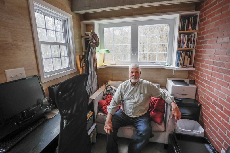 Larry Singleton’s tiny home has a number of amenities, including a television, pullout couch and washing machine.  Bob Andres / bandres@ajc.com