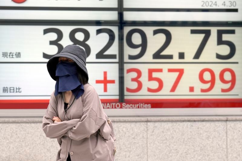 A person walks in front of an electronic stock board showing Japan's Nikkei 225 index at a securities firm Tuesday, April 30, 2024, in Tokyo. Asian shares mostly rose Tuesday, as investors kept their eyes on potentially market-moving reports expected later this week. (AP Photo/Eugene Hoshiko)