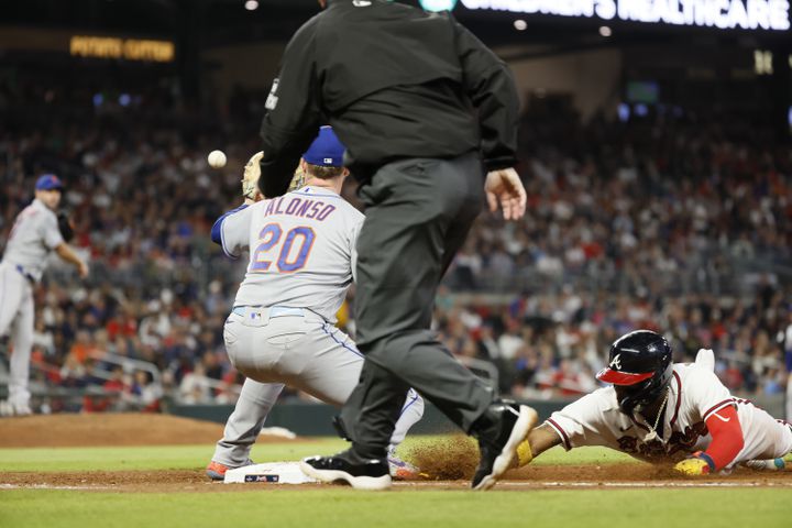 Braves right fielder Ronald Acuna Jr. (13) slides at the first base during the fourth inning of a baseball game against the New York Mets at Truist Park on Saturday, Oct. 1, 2022. Miguel Martinez / miguel.martinezjimenez@ajc.com