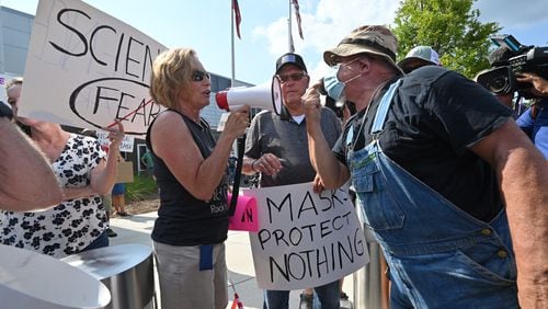 A demonstrator (right) demanding mask-mandate confronts a counter-protester at a rally in the parking lot of Cobb County School District's headquarters on Aug. 12, 2021. (Hyosub Shin / Hyosub.Shin@ajc.com)