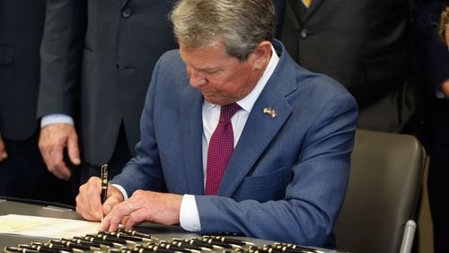Gov. Brian Kemp signs House 1105 during a ceremony at the Georgia Public Training Center in Forsyth. The new law adds numerous offenses that will require cash bail for release from jail. (Natrice Miller/ AJC)