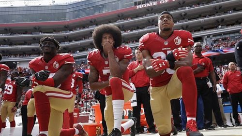 2016 AP YEAR END PHOTOS - San Francisco 49ers outside linebacker Eli Harold, left, quarterback Colin Kaepernick, center, and safety Eric Reid kneel during the national anthem before an NFL football game against the Dallas Cowboys in Santa Clara, Calif., on Oct. 2, 2016. (AP Photo/Marcio Jose Sanchez, File)