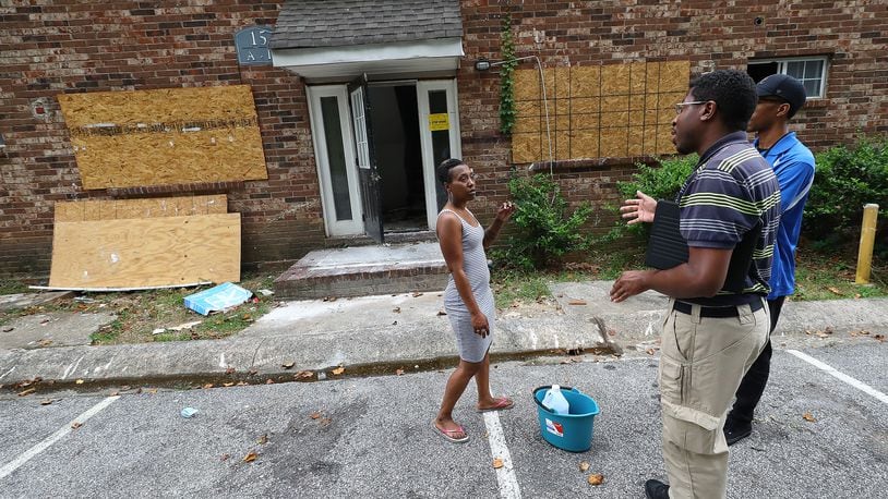 Tenant Daniel Russell (left) speaks with Atlanta zoning employees outside the burned out unit next to her apartment at the Pavilion Place apartments while code enforcement, zoning, and State Department of Community Affairs officials do a sweep on Monday, August 1, 2022, in Atlanta. An AJC investigations of dangerous apartment complexes prompted officials to promise a crackdown. “Curtis Compton / Curtis Compton@ajc.com