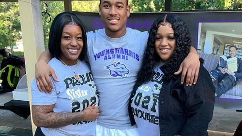 Artez Benton, center, and his sisters Arteria, left, and Bria after he graduated from Young Harris College last year.