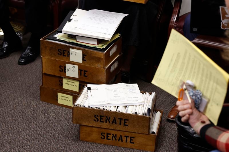 Stacks of paper bills sit on the floor Monday at the Senate Rules Committee meeting. (Natrice Miller/ Natrice.miller@ajc.com)
