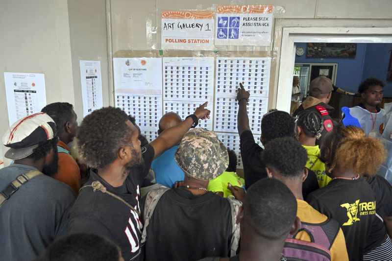 Voters check the list of electors at a polling station in the capital Honiara, Wednesday, April 17, 2024. Voting began across the Solomon Islands on Wednesday in the South Pacific nation's first general election since the government switched diplomatic allegiances from Taiwan to Beijing and struck a secret security pact that has raised fears of the Chinese navy gaining a foothold in the region. (Mick Tsikas/AAP Image via AP)