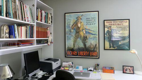 An office wall contains vintage World War II posters. The one on the right reads “Young men wanted for U.S. Navy.” The poster on the left is soliciting war loans. (Christian Gooden/St. Louis Post-Dispatch/TNS)
