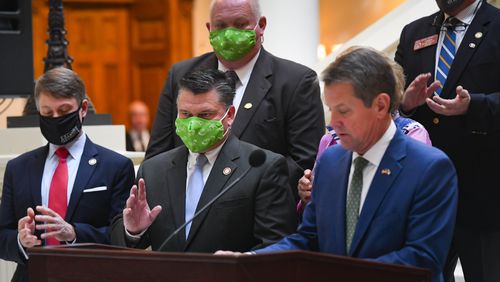 Brian Marlowe, in the green mask, responds as Gov. Brian Kemp, right, introduces him as the leader of the Rural Strike Team during a news conference at the State Capitol in Atlanta, October 21, 2020. JOHN AMIS FOR THE ATLANTA JOURNAL-CONSTITUTION