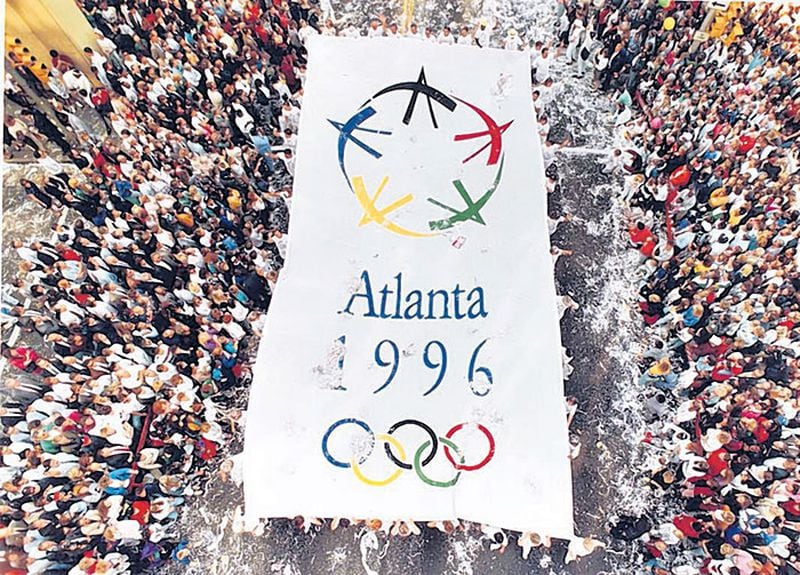 Celebrators carry an Olympic banner on Peachtree Street downtown on Sept. 24, 1990, after Atlanta was chosen to host the 1996 Summer Olympics. In contrast to such efforts today, Atlanta’s campaign was paid for without government funding.