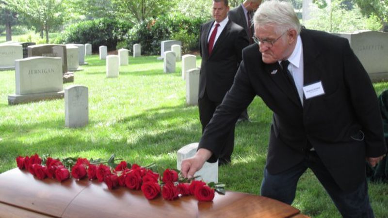 German citizen Manfred Römer places a rose on the casket of American airman Lt. John W. Herb, during a 2015 military funeral at Arlington National Cemetery. Römer was five years old when he saw Herb’s Mustang P-51 crash in the woods southeast of Hamburg. Decades later he initiated a search to find the body. Photo: courtesy Riverside Military Academy