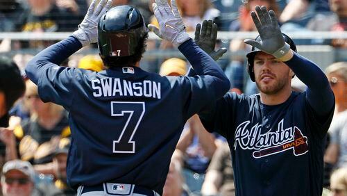 Atlanta Braves' Dansby Swanson (7) celebrates with teammate Freddie Freeman after hitting a solo home run off Pittsburgh Pirates starting pitcher Gerrit Cole in the first inning of a baseball game in Pittsburgh, Sunday, April 9, 2017. (AP Photo/Gene J. Puskar)