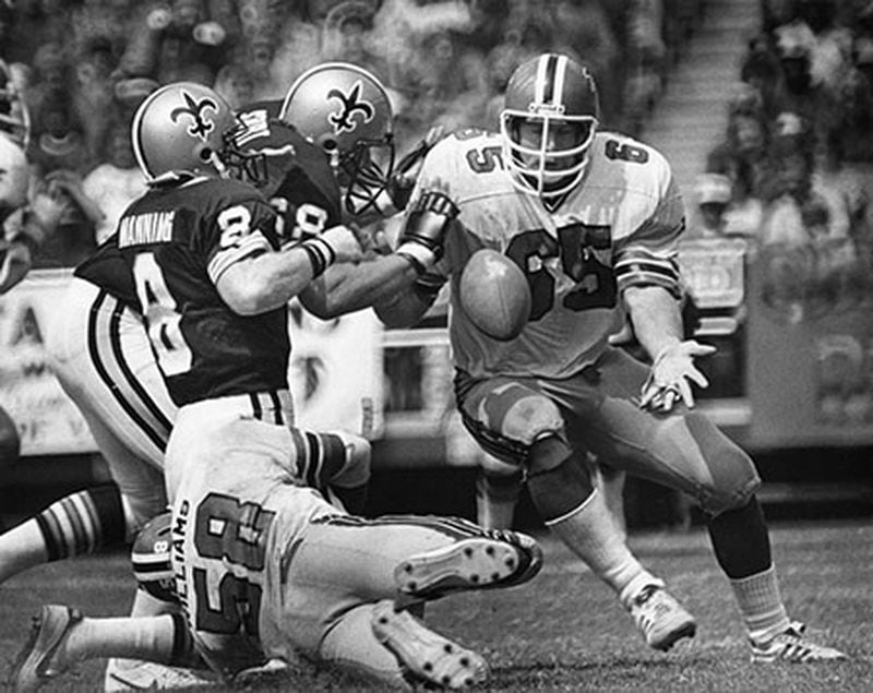 Falcons' defensive lineman Don Smith reaches for a lose ball by Saints quarterback Don Smith. (AJC File)