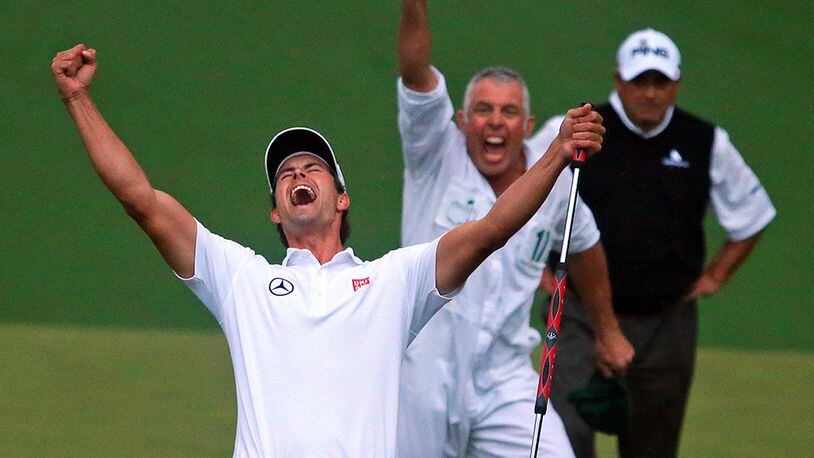 With runner-up Angel Cabrera looking on (background), Adam Scott and his caddy, Steve Williams (center), celebrate the putt dropping on the second playoff hole on the 10th green to win the Masters Tournament at Augusta National Golf Club.