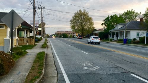 This is the portion of Church Street that will be narrowed from four to two lanes with wider sidewalks, protected bike lanes on each side and elimination of the “sharrow” lane on the left. This is looking south from the cemetery entrance towards Commerce Drive. Bill Banks for the AJC