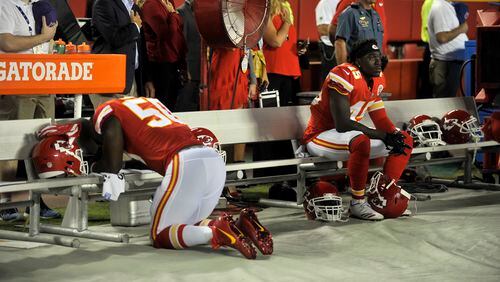 Kansas City Chiefs linebacker Justin Houston (50) appears to be praying and linebacker Ukeme Eligwe (45) sits on the bench during the playing of the national anthem before an NFL football game against the Washington Redskins in Kansas City, Mo., Monday, Oct. 2, 2017.