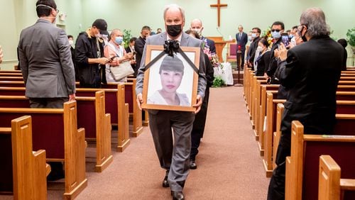 A photograph of Daoyou Feng is carried out of Lee's Funeral Home after her funeral in Norcross on April 4. The 44-year-old was among the eight people slain in metro Atlanta spa shootings last month. (Photo: Steve Schaefer for The Atlanta Journal-Constitution)