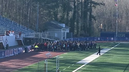 Walton High School students walk out onto the football field on March 14 as part of a national protest against gun violence that took place in schools across the country. Special to the AJC.