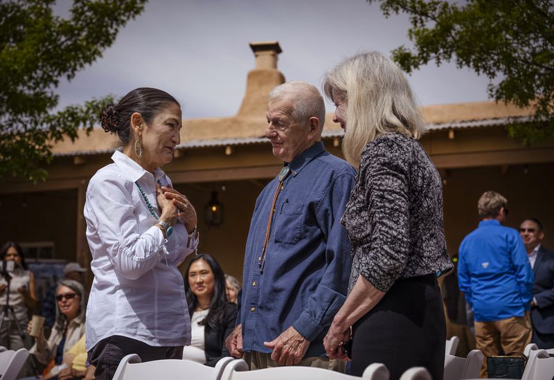 Interior Secretary of the Deb Haaland, chats with George Franzen, Eastern Sandoval Citizens Association President, and Mary-Rose de Valladares at El Zócalo Plaza in Bernalillo, N.M., Thursday, April 18, 2024. Haaland signed Public Land Order 7940, which protects more than 4,200 acres of Bureau of Land Management-managed public lands and prevents new mining claims, mineral sales, and oil and gas leases for the next 50 years. (Chancey Bush/The Albuquerque Journal via AP)