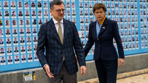 Ukraine Foreign Minister Dmytro Kuleba, left, leads his Latvia counterpart Baiba Braze after placing flowers at a memorial wall of Ukrainian soldiers killed during the war at Saint Michael cathedral in Kyiv, Ukraine, Friday, April 26, 2024. Braze visited Kyiv on her first foreign trip to discuss aid for Ukraine, including a plan to build drones. (AP Photo/Francisco Seco)