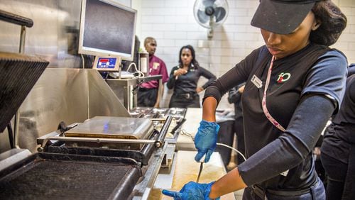 Shanterika Shealey uses a tethered knife to cut a sandwich at Fresh to Order at Hartsfield-Jackson International Airport. JONATHAN PHILLIPS / SPECIAL
