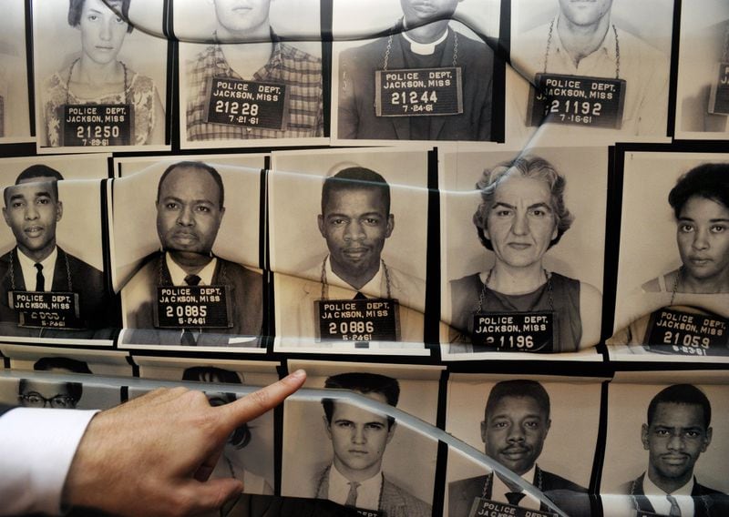 On the outside of a full-size replica of a Freedom Rider bus is a police mugshot of Congressman John Lewis, who was arrested many times during protests of the 1960s. The Freedom Rider exhibit is part of the civil rights gallery at the National Center for Civil and Human Rights. (DAVID TULIS / AJC Special)