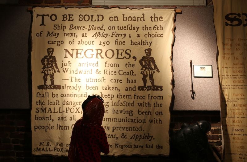A youngster looks over a slave notice at the APEX Museum before the start of the Annual Kwanzaa ceremony. Courtesy of Akili-Casundria Ramsess