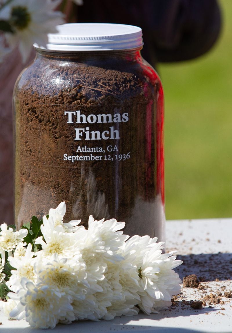 A jar filled with soil from where Thomas Finch was taken sits on a table during a May 18 ceremony by the Fulton County Remembrance Coalition near Grady Memorial Hospital. STEVE SCHAEFER / SPECIAL TO THE AJC