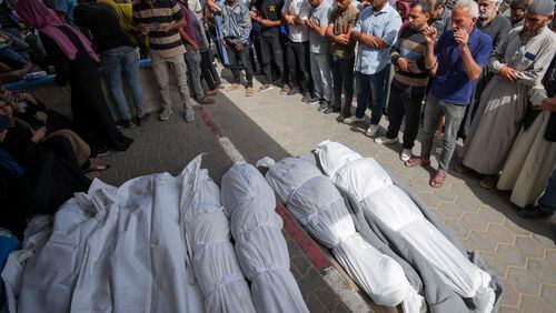 Mourners pray over the bodies of Palestinians who were killed in an Israeli airstrike in Nuseirat, at the Al Aqsa hospital in Deir al Balah, Gaza Strip, Sunday, May 19, 2024. (AP Photo/Abdel Kareem Hana)