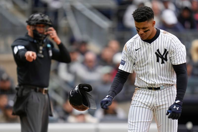 New York Yankees' Juan Soto slams his helmet on the ground after striking out during the eighth inning of the baseball game against the Toronto Blue Jays at Yankee Stadium Friday, April 5, 2024, in New York. (AP Photo/Seth Wenig)