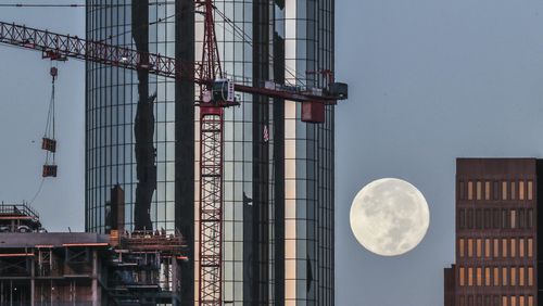 October 2, 2020 Atlanta: Perfect autumn weather brought a harvest moon over downtown Atlanta as a construction crane operating Friday morning, Oct. 2, 2020 swung into place materials for workers against the backdrop of the Westin Peachtree Plaza, Atlanta.  (John Spink / John.Spink@ajc.com)