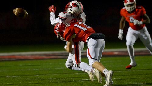 Allatoona's Fisher Paulsen (13) hits Gainesville wide receiver Lenny Chatman (22) as he goes for a pass during the first half of Friday's state playoff game at Allatoona. (Daniel Varnado/Special)
