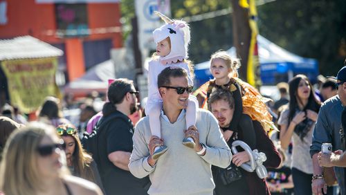 October 17, 2015 Atlanta - Monet Aouad (center) rides on her father Robert's shoulders as they look for a spot to watch the Little Five Points Halloween Parade in Atlanta on Saturday, October 17, 2015. The annual parade brought out tens of thousands of people to watch the antics. JONATHAN PHILLIPS / SPECIAL
