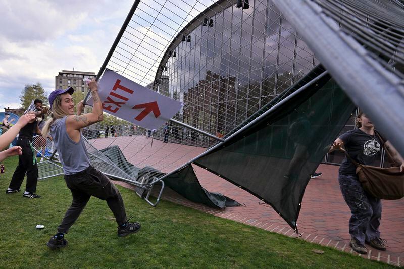 Demonstrators tear down barricades that had been erected outside a pro-Palestinian encampment at MIT, May 6, 2024, in Cambridge, Mass. Several hundred demonstrators crossed the barricades to join pro-Palestinian demonstrators that been given a deadline to leave the encampment. (AP Photo/Josh Reynolds)