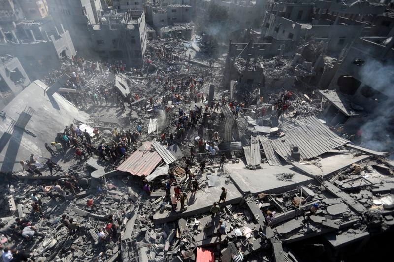 FILE - Palestinians inspect the rubble of destroyed buildings following Israeli airstrikes on town of Khan Younis, southern Gaza Strip on Oct. 26, 2023. (AP Photo/Mohammed Dahman, File)