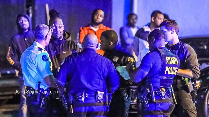 Atlanta police investigators speak with possible witnesses to a shooting in the parking lot of Anchor Down Grille and Lounge in Buckhead Friday morning. (Credit: