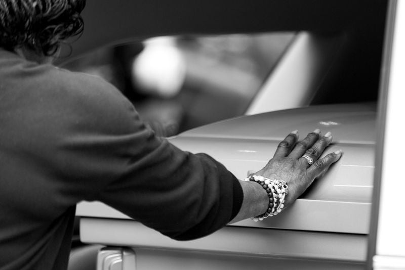 A mourner touches the casket of Marcus Johnson.